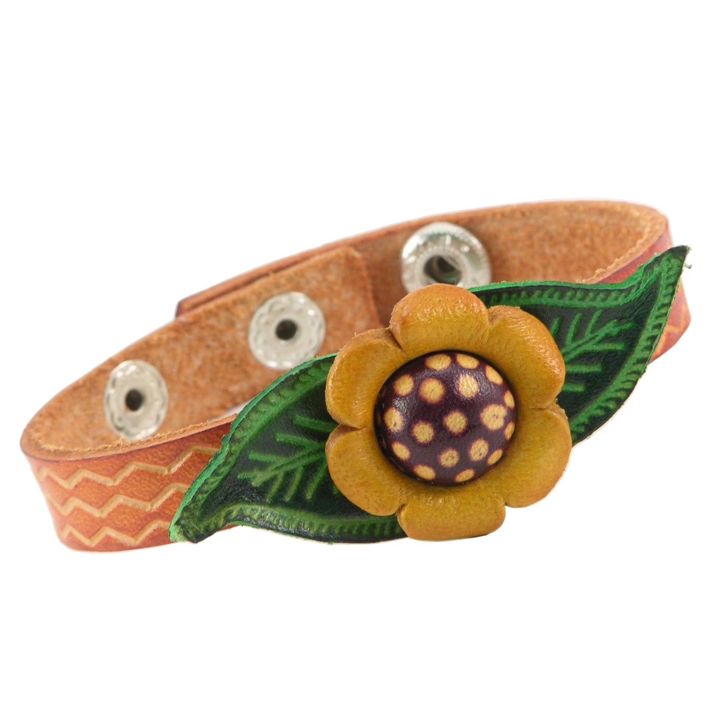 A handmade leather bracelet featuring a tan strap with a stamped chevron pattern, a green and yellow and brown leather flower charm, and silver metal snap buttons.