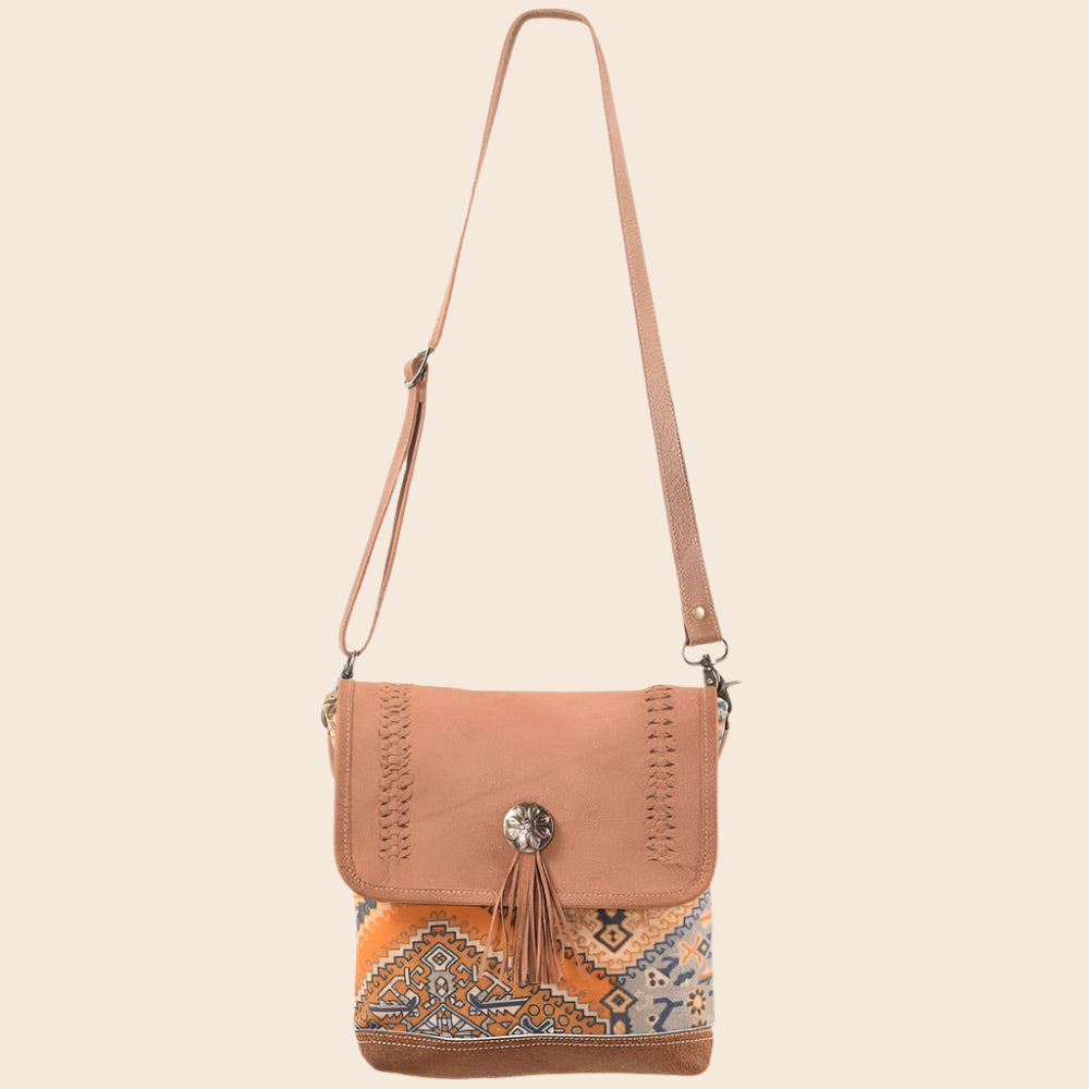Brown crossbody bag with patterned flap on a white background