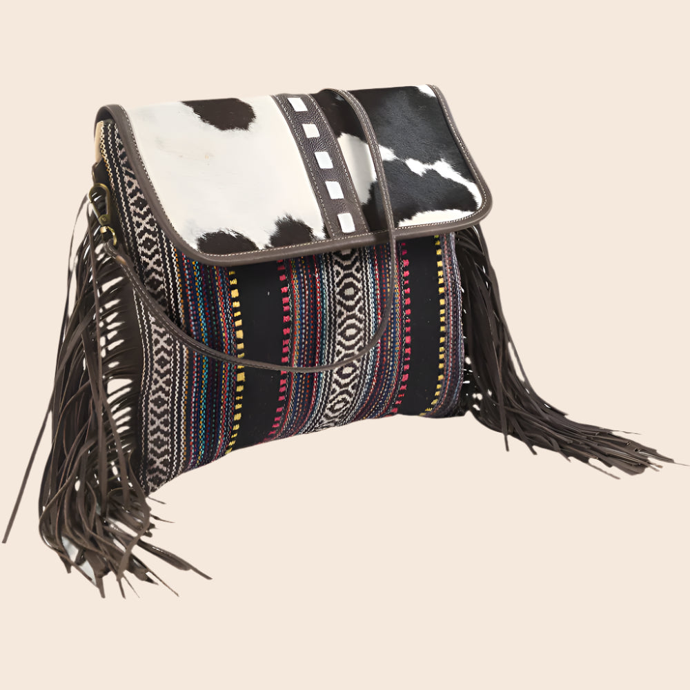 Handbag with cowhide leather top and multicolored patterned body on a white background