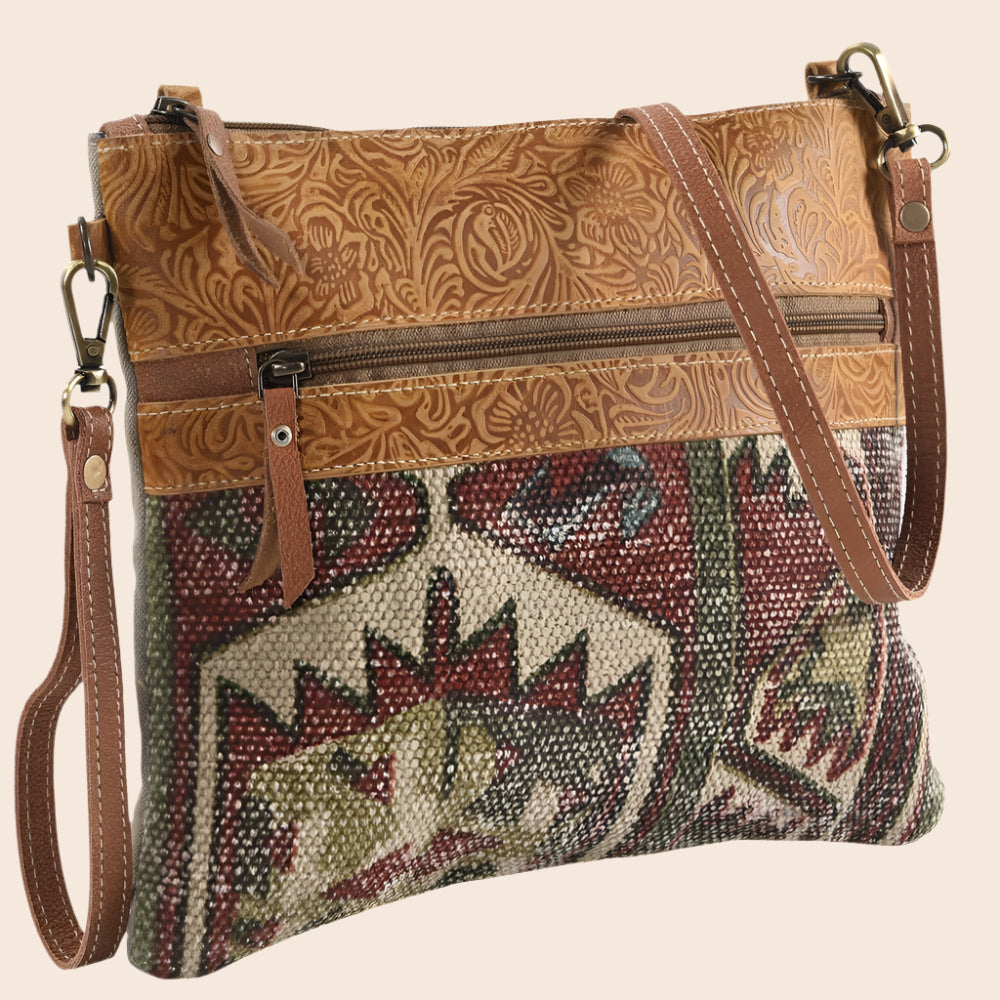 Brown leather and patterned fabric crossbody bag on a white background