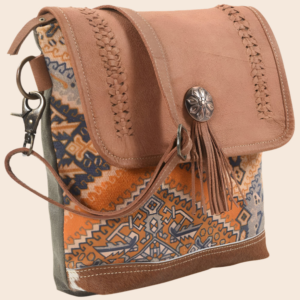 Brown leather and fabric handbag with intricate patterns on a white background