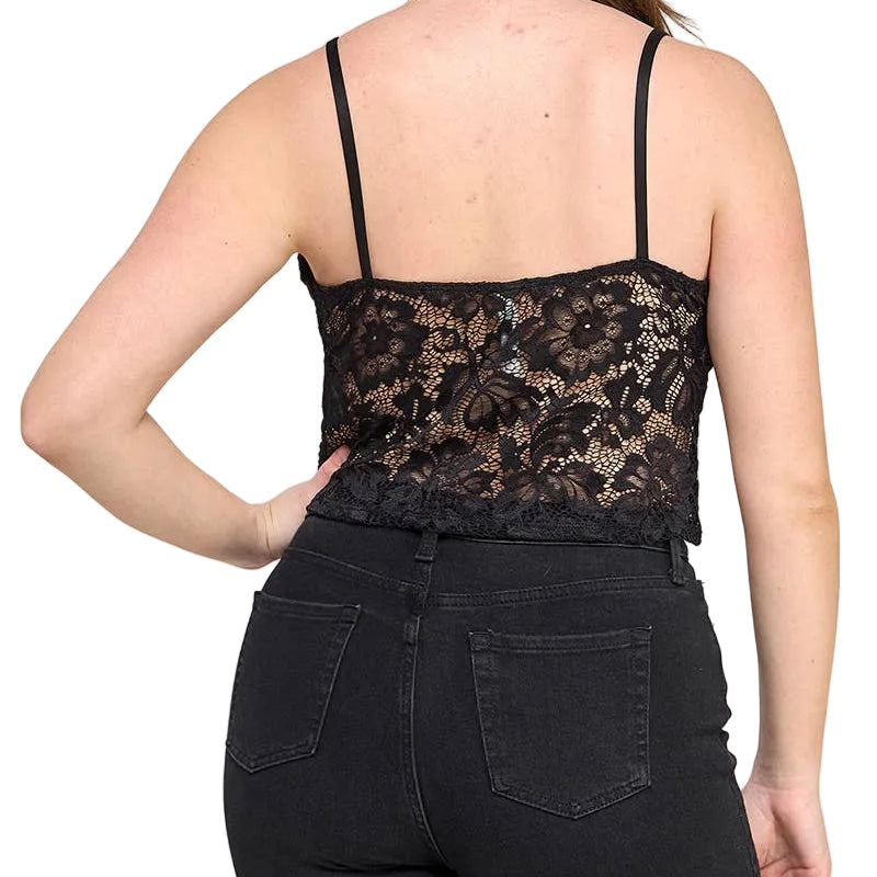 A woman shown from the back wearing a black lace spaghetti-strap camisole top and black jeans against a light gray studio background.