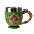 A green fantasy-themed mug with a metallic silver stainless steel rim, a brown wooden handle decorated with purple mushrooms, and a front relief of three purple mushrooms inside an ornate frame.