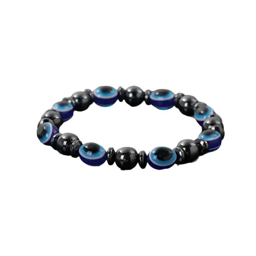 A stretchable bracelet made with black and blue acrylic beads designed to resemble evil eyes, set against a white background.