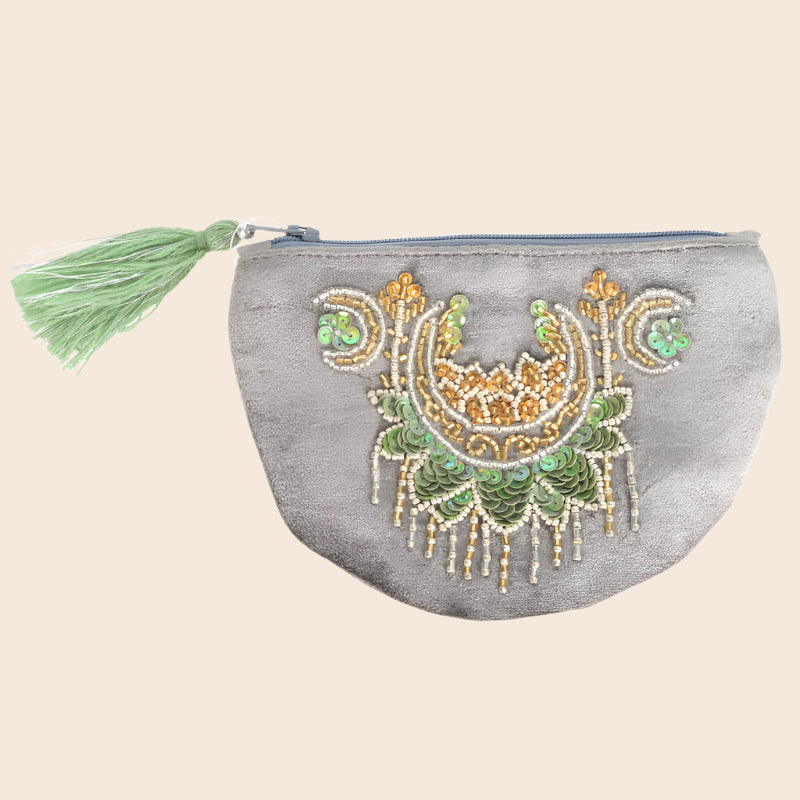 Gray pouch with decorative green and gold patterns and a tassel on a white background