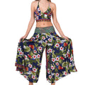 A model wearing a floral halter top and matching palazzo pants with an embellished waistband.