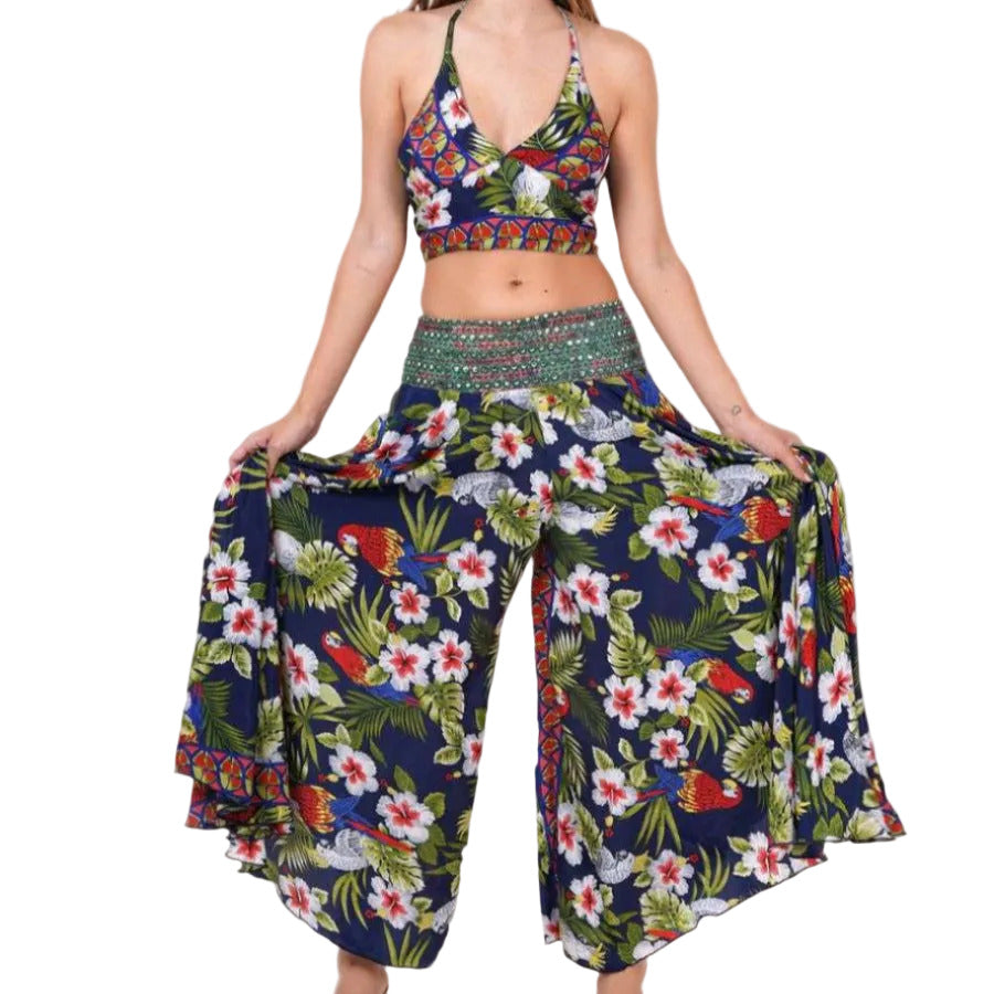 A model wearing a floral halter top and matching palazzo pants with an embellished waistband.