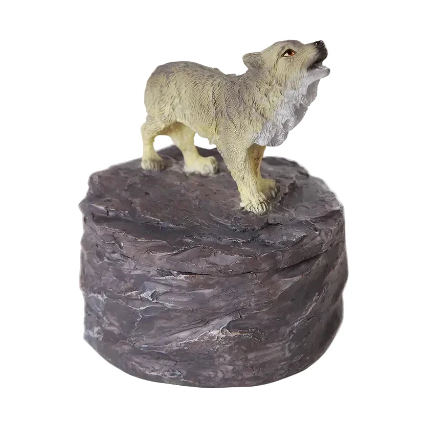 Small trinket box featuring a statue of a wolf on a rocky base with a white background