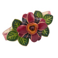 A handmade leather flower bracelet on a white background. The bracelet features a large central flower with burgundy and purple and pink petals, a brown center, and green leaves with light green veins, all outlined in tan.