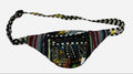 A multicolor patterned fanny pack with a black and white striped adjustable strap, shown against a plain light gray background.