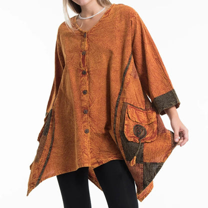 Woman wearing an orange poncho tunic with brown accents on a white background