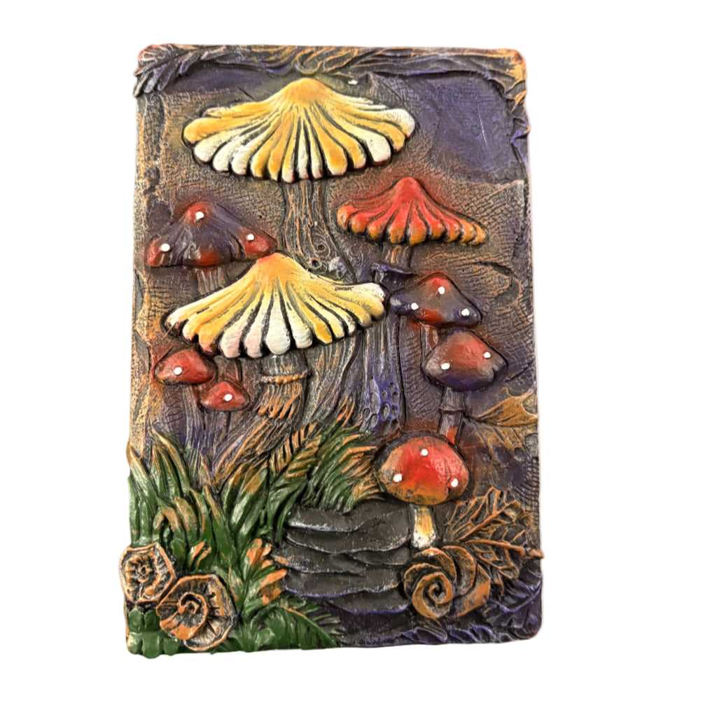 A decorative box with a three-dimensional mushroom design in shades of yellow, red, and brown with green foliage details.