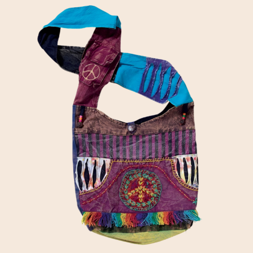 Colorful handbag with peace symbol and fringe details on a beige background