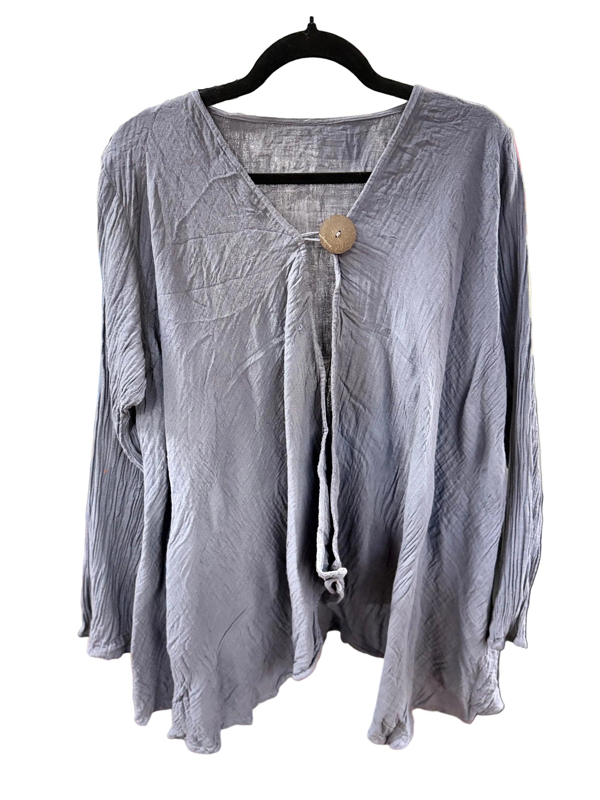 A crinkled, long-sleeve lavender-gray blouse hanging on a black hanger on a white background. It features a split V-neckline with a central tie and a single large wooden button.