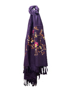 A deep purple woven scarf with colorful floral embroidery and fringe on a white background.